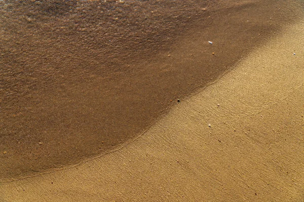 Сухой песок на пляже, оставленные следы, освещенные солнцем — стоковое фото