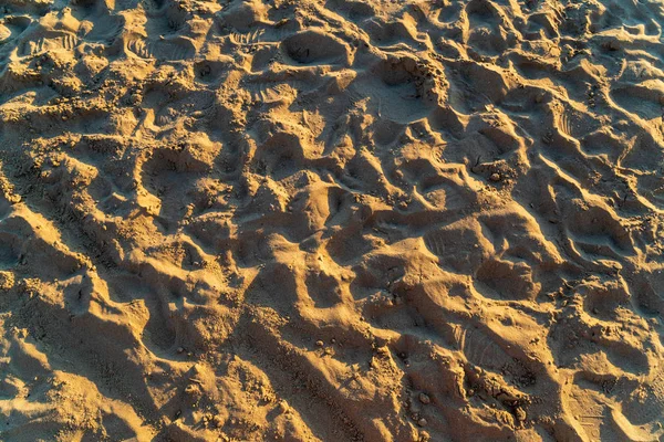 Сухой песок на пляже, оставленные следы, освещенные солнцем — стоковое фото