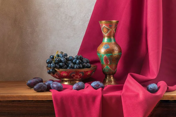 淡淡的生活，葡萄和李子，背景是深红色的窗帘 — 图库照片
