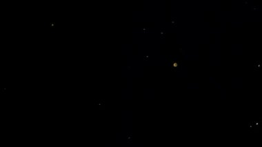 Parçacıklar siyah arka planda Bokeh arasında rastgele hareket ederler. Soyut dekoratif arkaplan