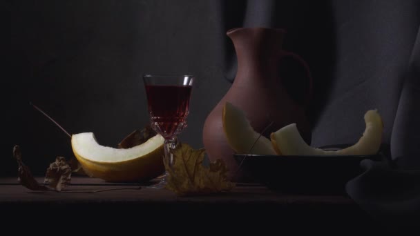 Stillleben mit geschnittener Melone, einem Tonkrug Wein und Herbstblättern — Stockvideo