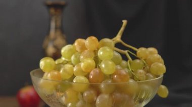 Karanlık bir arka planda elmalar ve üzümlerle dolu bir hayat