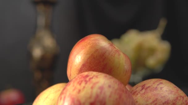 Натюрморт с яблоками и виноградом на темном фоне — стоковое видео