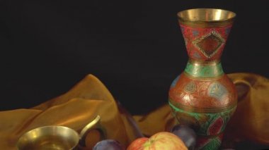 Karanlık bir arka planda erik ve elmalarla dolu bir hayat