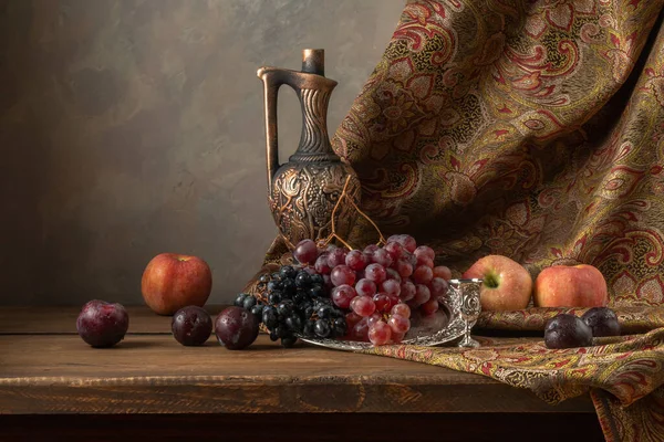 Still life with grapes, plums and apples