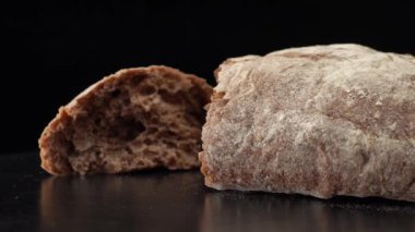 Rye ciabatta ekmeği siyah arkaplanı kapatır