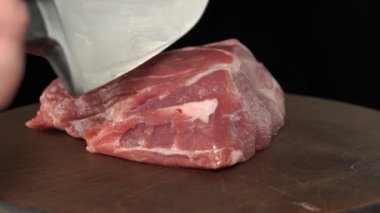 Siyah arka planda bir biftek için bir parça domuz eti..