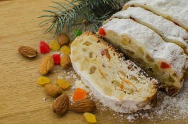 Noel stollen köknar twigs, darkfestive zemin üzerine ışıklar ve ve çilek. Noel kutlaması için bu geleneksel Alman tatlı yakın çekim.