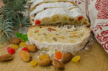 Noel stollen köknar twigs, darkfestive zemin üzerine ışıklar ve ve çilek. Noel kutlaması için bu geleneksel Alman tatlı yakın çekim.