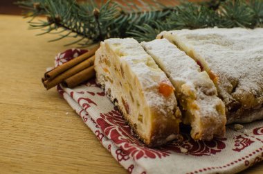 Noel stollen köknar twigs, darkfestive zemin üzerine ışıklar ve ve çilek. Noel kutlaması için bu geleneksel Alman tatlı yakın çekim.