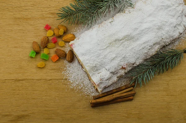 Noel stollen köknar twigs, darkfestive zemin üzerine ışıklar ve ve çilek. Noel kutlaması için bu geleneksel Alman tatlı yakın çekim.