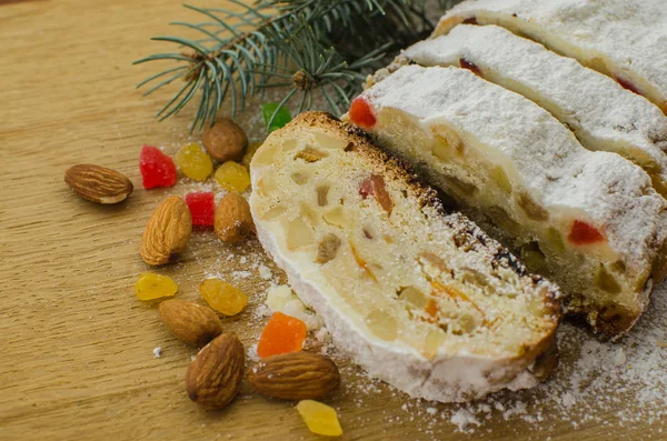 Noel stollen köknar twigs, darkfestive zemin üzerine ışıklar ve ve çilek. Noel kutlaması için bu geleneksel Alman tatlı yakın çekim.