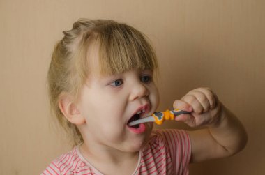 Mutlu küçük kız dişlerini fırçalama. Kopya alanı