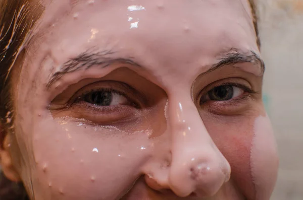 Good looking woman having a face mask on half of her face