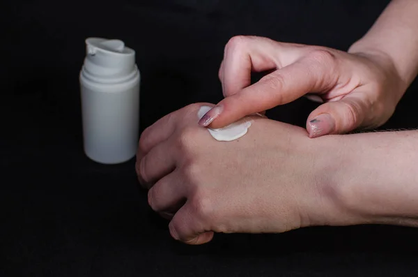 Smear cream on woman hand. Lotion for face or body.