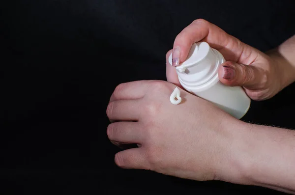 Smear cream on woman hand. Lotion for face or body.