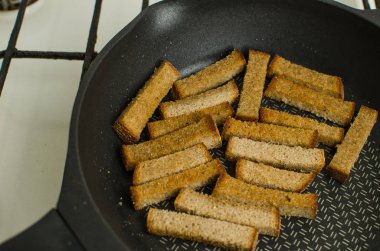 Tost kızartma tavası baharatlar ile üzerinde yanmış. Sarımsak sosu ve barbekü sosu ile beyaz bir tabakta servis