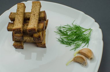 Tost kızartma tavası baharatlar ile üzerinde yanmış. Sarımsak sosu ve barbekü sosu ile beyaz bir tabakta servis