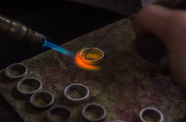 Profesyonel aletlerle mücevher yapımı. Makro atış. El yapımı kuyumcu, mücevher üretimi. Eriyen metal