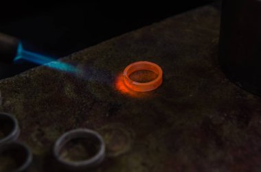 Profesyonel aletlerle mücevher yapımı. Makro atış. El yapımı kuyumcu, mücevher üretimi. Eriyen metal