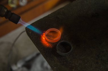 Profesyonel aletlerle mücevher yapımı. Makro atış. El yapımı kuyumcu, mücevher üretimi. Eriyen metal