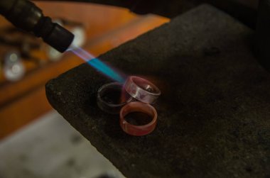 Profesyonel aletlerle mücevher yapımı. Makro atış. El yapımı kuyumcu, mücevher üretimi. Eriyen metal