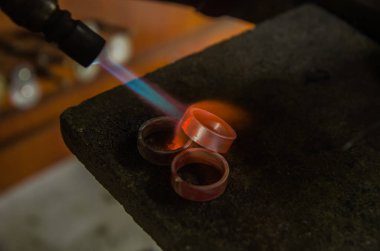 Profesyonel aletlerle mücevher yapımı. Makro atış. El yapımı kuyumcu, mücevher üretimi. Eriyen metal