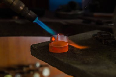 Profesyonel aletlerle mücevher yapımı. Makro atış. El yapımı kuyumcu, mücevher üretimi. Eriyen metal
