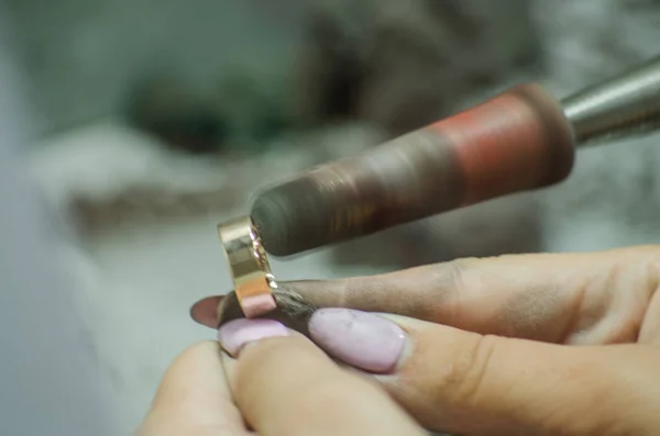 Pulir un anillo de bodas. Producción de joyas. Copiar espacio — Foto de Stock