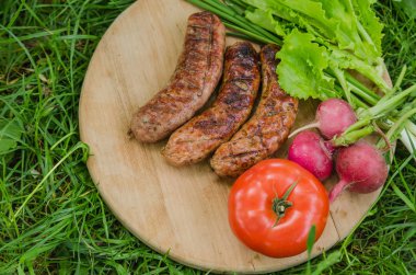 Eski ahşap arka plan üzerinde ızgara sosis ve sebze. Üstte görüntü.