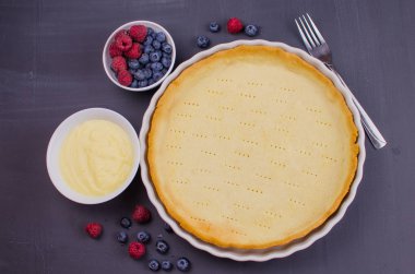 Siyah ahşap arka plan üzerinde vanilya krem ile Lezzetli Yaban Mersini tartlets. Üst te. şekerleme kavramları, fırın konsepti
