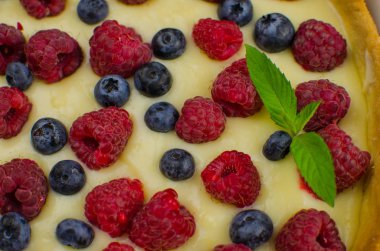 Siyah ahşap arka plan üzerinde vanilya krem ile Lezzetli Yaban Mersini tartlets. Üst te. şekerleme kavramları, fırın konsepti