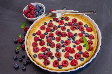 Siyah ahşap arka plan üzerinde vanilya krem ile Lezzetli Yaban Mersini tartlets. Üst te. şekerleme kavramları, fırın konsepti