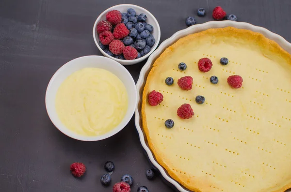 Läckra blåbär Tartlets med vaniljkräm på svart trä bakgrund. Översta vyn. konfektyrkoncept, bageri koncept — Stockfoto