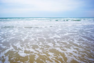 Baharda turkuaz denizden beyaz köpükle deniz dalgalarının güzel manzarası.