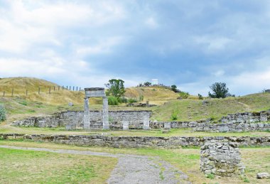  Antik gri sütunların güzel manzarası, mavi gökyüzüne karşı yeşil tepelerdeki taşlar. 