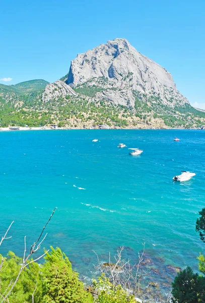 Beautiful view of the turquoise sea, rocks and white boats