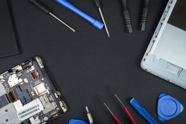 Cep telefonu ve özel amaçlı araçlar ana merkezi flatlay tarzı bir boşluk ile siyah masaüstünde ayrıntılarını. Onarım akıllı telefon. Tamirci İşyeri.