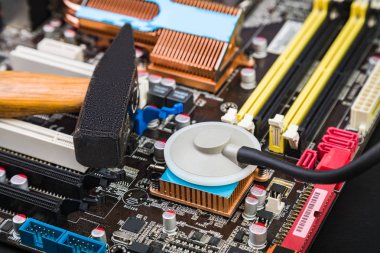 Bir kırık anakart, çekiç ve siyah bir tabloda stetoskop ile İşyeri tamirci. Kırmak veya onarmak için?