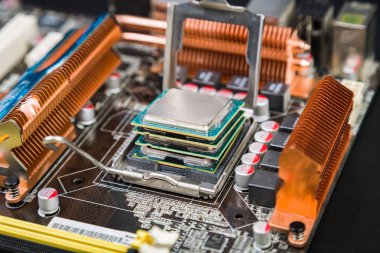 Dört işlemci birbirinin üstüne siyah bir masanın üzerinde yatan bir eski ve tozlu oyun anakart içinde. Bilgisayar yeni teknolojileri geçmiş