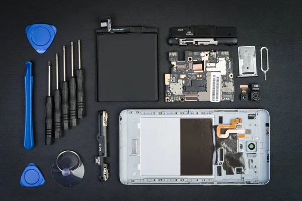 Demonte cep telefonu ile kaldırılan perde ve özel amaçlı araçlar üstünde siyah okul sırası. Flatlay stil ayrıntılarda Smartphone.