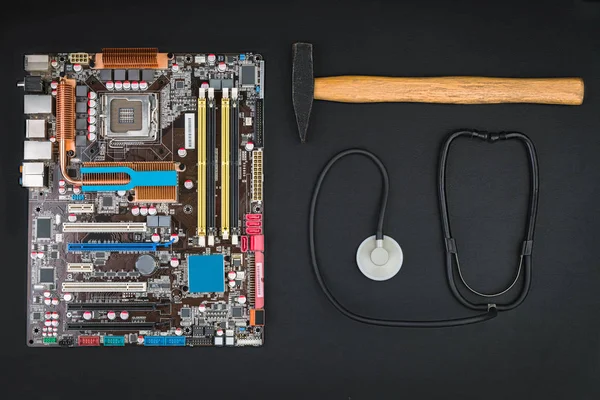 Anakart, çekiç ve stetoskop siyah bir tablo. Onarmak ya da bilgisayar gürültüyle çarpmak.