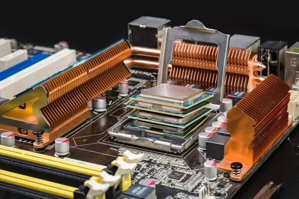 Dört işlemci birbirinin üstüne siyah bir masa üzerine portakal radyatörler ile bir oyun anakart yalan. İlerleme ve yeni teknolojileri