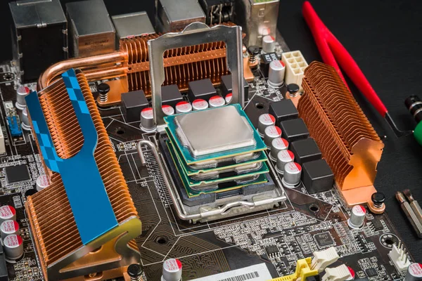 Dört işlemci birbirinin üstüne siyah bir masa üzerine portakal radyatörler ile anakart içinde yalan. Bir bilgisayar tamircisi İşyeri