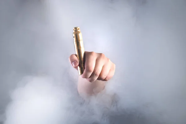 Adam vaping mermiyi duman içinde tutuyor. Sigara için alternatif