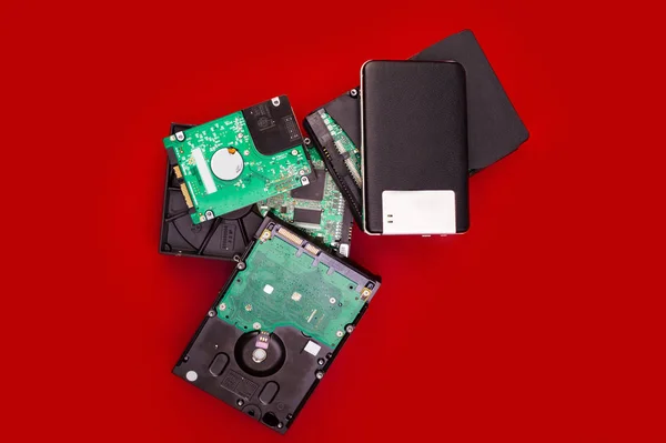 External and internal hard drives in a pile on the board. Computer storage concept.