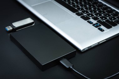 Taşınabilir hdd bir dizüstü bilgisayar ile usb birden parlamak götürmek siyah bir masaya bağlı. Veri depolama kavramı