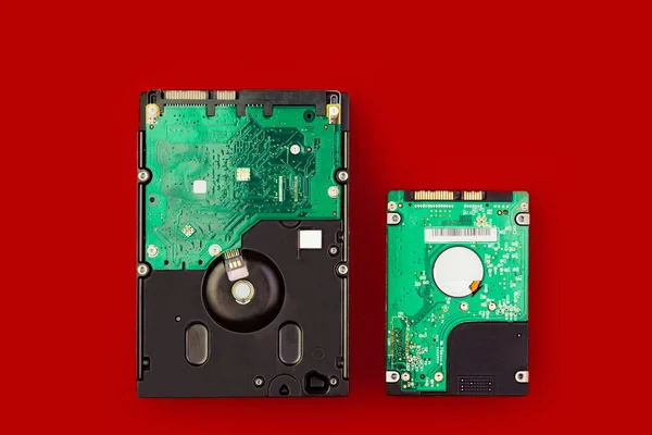 Büyük bir sabit disk ve kırmızı bir arka plan üzerinde küçük bir hdd. Bilgisayar depolama kavramı