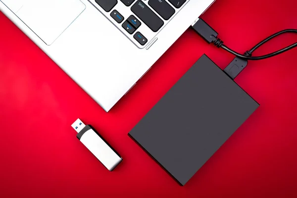 Taşınabilir hdd bir dizüstü bilgisayar ile usb birden parlamak götürmek kırmızı bir tablo, düz yatıyordu bağlı. Veri depolama kavramı