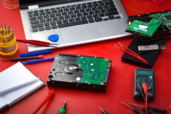 Sabit disk, bilgisayar parçaları, dizüstü bilgisayar ve kırmızı kartı üzerindeki onarım için özel araçlar. Tamirci'nın işyeri kavramı